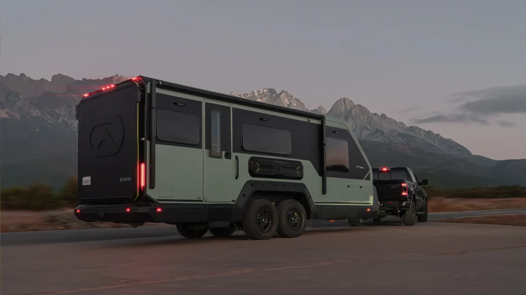 Evotrex PG5 hybrid RV trailer being towed on a mountain highway